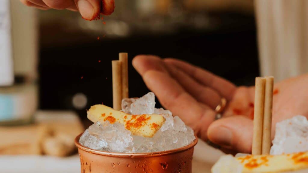 Verre de Moscow Mule garnit d'une tranche de gingembre et de piment