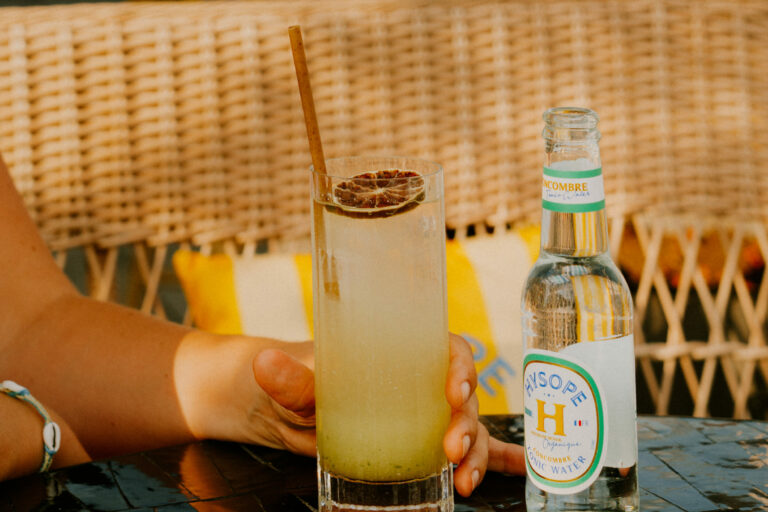 Un cocktail servi avec une bouteille de Tonic Concombre Hysope