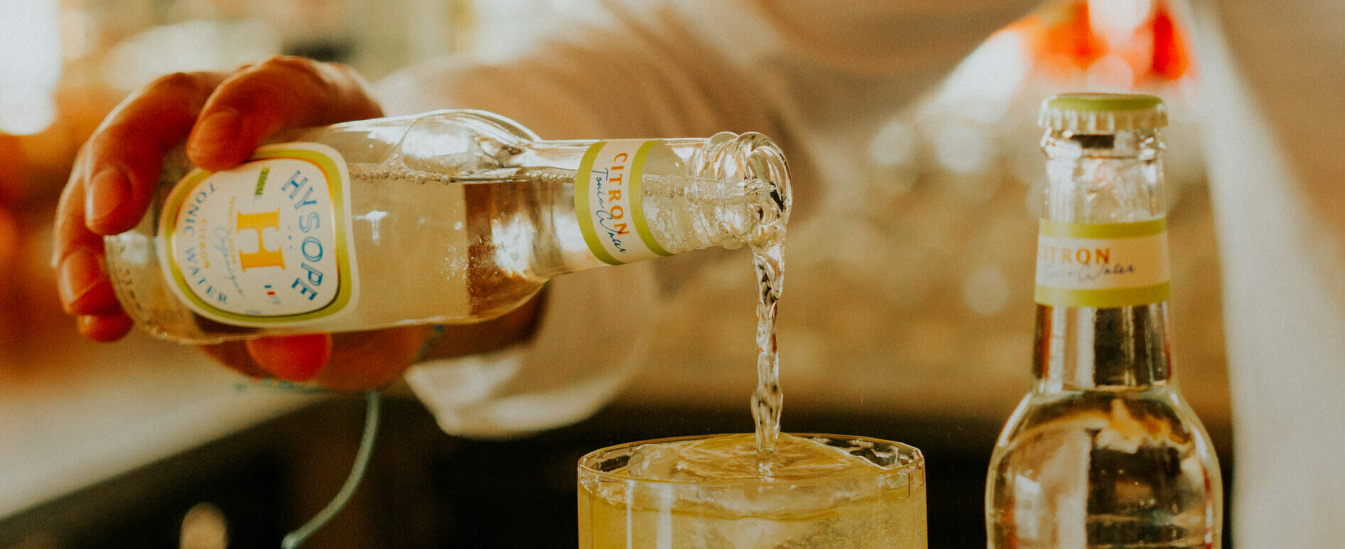 Du Tonic Water Citron Hysope est versé dans un verre à cocktail