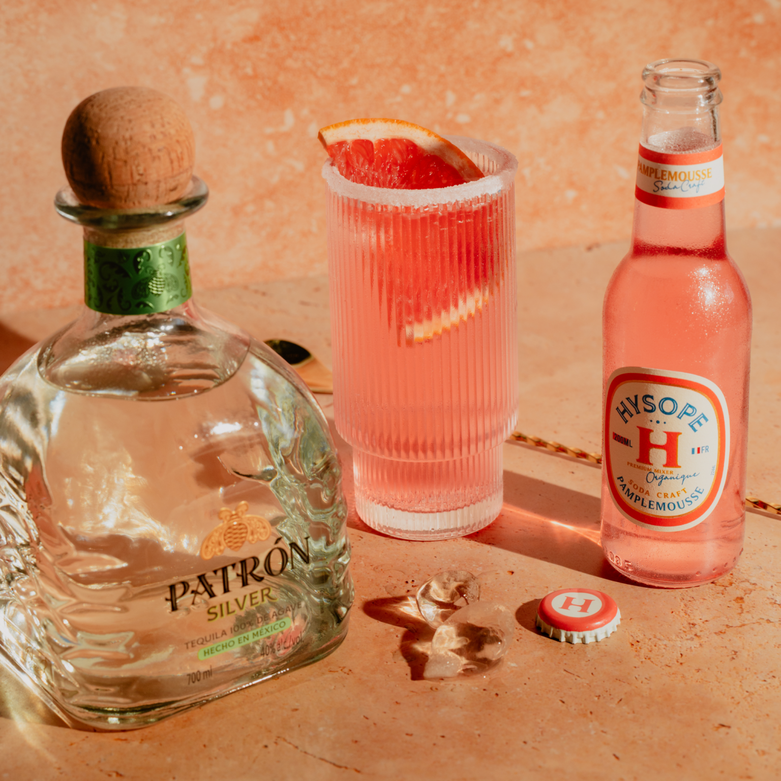 Ingrédients du cocktail Paloma avec bouteille de tequila Patrón Silver, soda Hysope pamplemousse et verre servi
